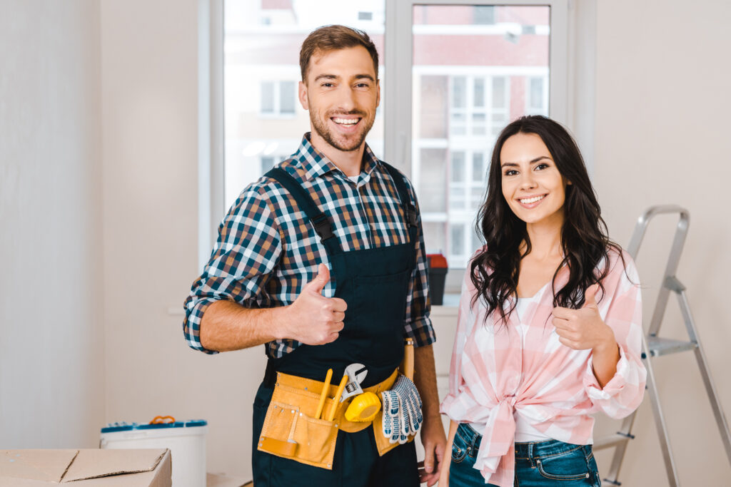 attractive woman and handsome handyman showing thumbs up